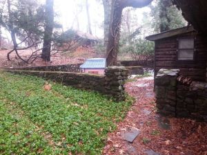 Beatrice Fox Auerbach's summer cottage, field stone structures in front.